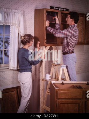 Young couple remodeling kitchen cabinets. Stock Photo