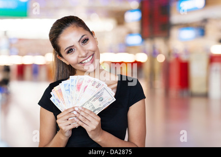 attractive young woman holding cash outside casino Stock Photo