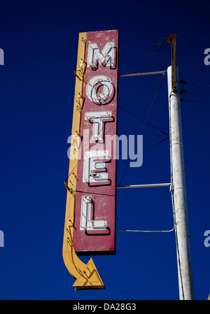 A vintage motel sign with an arrow in front of blue sky Stock Photo