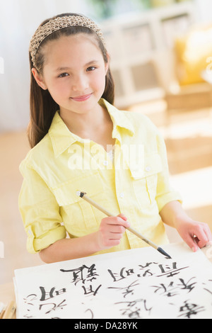 Portrait of girl (8-9) painting japanese symbols Stock Photo