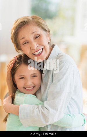 Grandmother embracing granddaughter (8-9) Stock Photo