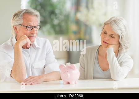 Senior couple looking at piggybank Stock Photo