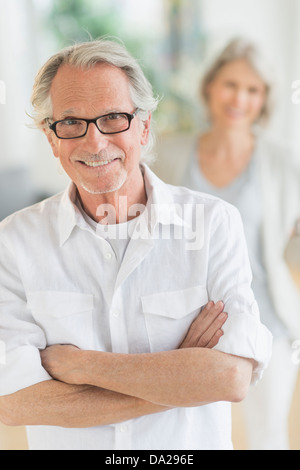 Portrait of senior man, woman in background Stock Photo