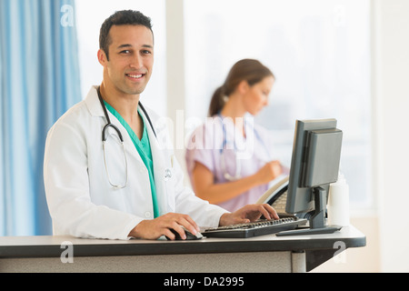 Male and female nurses working at nurse's station in hospital Stock Photo