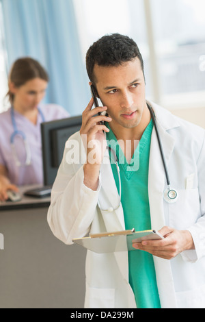 Male and female nurses working at nurse's station in hospital Stock Photo