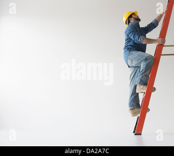 Man climbing up ladder Stock Photo