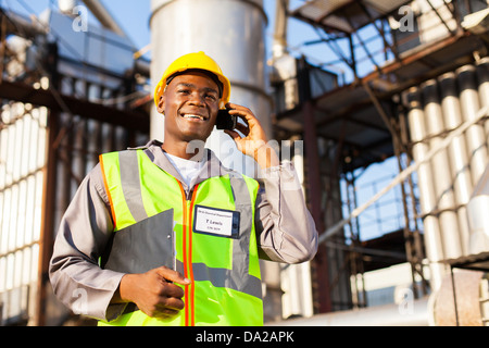 african oil and chemical worker talking on cell phone Stock Photo