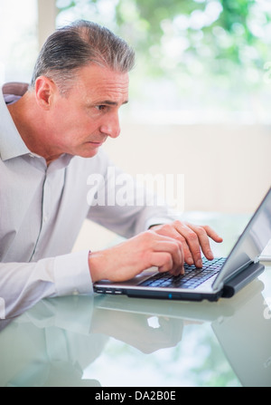 Portrait of tired man working on laptop Stock Photo