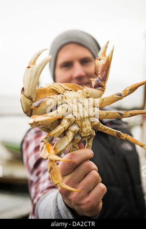 USA, Oregon, Rockaway Beach, Portrait of man showing crab Stock Photo
