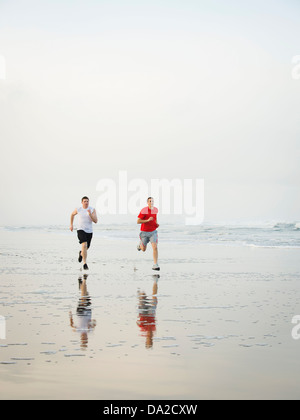 USA, Oregon, Rockaway Beach, Young adult men running on beach Stock Photo