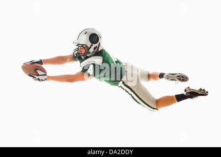 Portrait of American football player catching ball Stock Photo