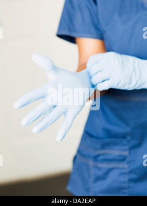 Close-up of nurses hands - putting on surgical gloves Stock Photo