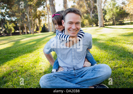 USA, California, Irvine, Daughter (4-5) embracing her father in park Stock Photo