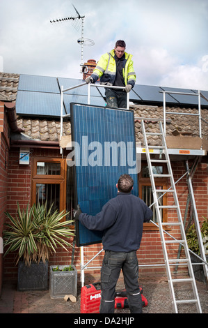 installing solar photo voltaic roof panels Stock Photo