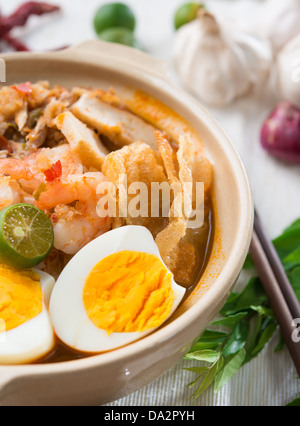 Prawn noodles or prawn mee. Famous Singapore food spicy fresh cooked har mee in clay pot with hot steam. Asian cuisine. Stock Photo