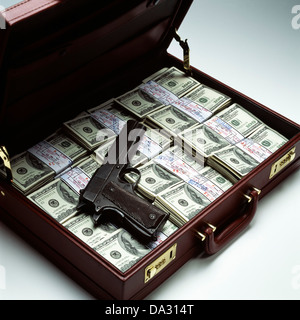 Briefcase with stacks of bundled 100 US Dollar bills and gun Stock Photo