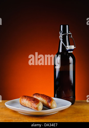 still life with grilled sausages and bottle of beer Stock Photo