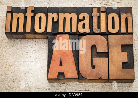 information age in vintage letterpress wood type on a grunge painted barn wood background Stock Photo