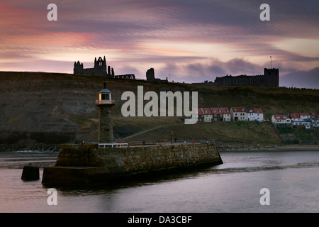 View of the river Esk and Whitby Harbour from the west pier at dawn in winter, with the distant Abbey and St Mary's church. Stock Photo