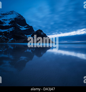 Mountain peaks rise above Bunes beach in spring twilight light, Moskenesoy, Lofoten Islands, Norway Stock Photo