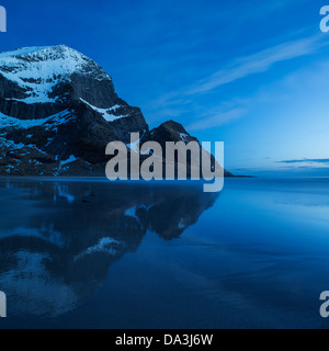 Mountain peaks rise above Bunes beach in spring twilight light, Moskenesoy, Lofoten Islands, Norway Stock Photo