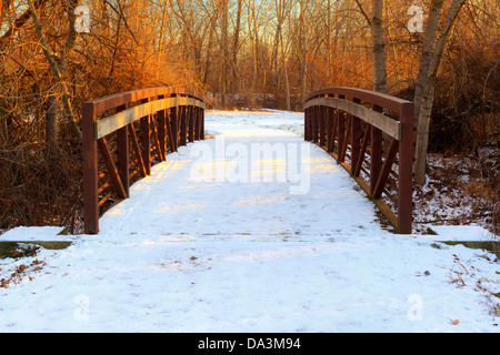 Symmetrical view of pedestrian bridge over creek in downtown Eagle, Idaho, by Boise River on winter evening Stock Photo