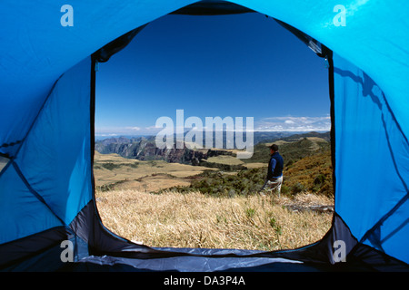 View from inside a tent of a man looking to the landscape at Espraiado Canyon, in the highlands of southern Brazil. Stock Photo