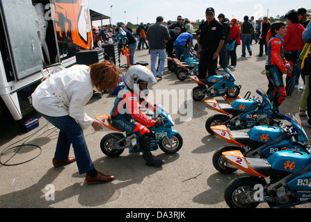 A mother helps his son before the start of Mini bikes races competition for childs in Palma de Mallorca, Spain Stock Photo