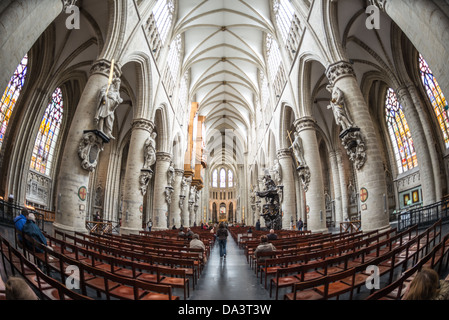 BRUSSELS, Belgium — A wide-angle shot of the nave at the Cathedral of St. Michael and St. Gudula (in French, Co-Cathédrale collégiale des Ss-Michel et Gudule) looking from the entrance down towards the altar. A church was founded on this site in the 11th century but the current building dates to the 13th to 15th centuries. The Roman Catholic cathedral is the venue for many state functions such as coronations, royal weddings, and state funerals. It has two patron saints, St Michael and St Gudula, both of whom are also the patron saints of Brussels. Stock Photo