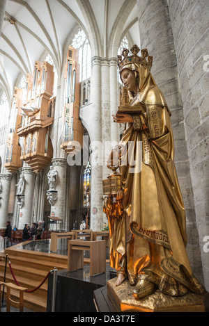 BRUSSELS, Belgium - A statue of Saint Gudula (with the pipe organ in the background) at the Cathedral of St. Michael and St. Gudula (in French, Co-Cathédrale collégiale des Ss-Michel et Gudule). A church was founded on this site in the 11th century but the current building dates to the 13th to 15th centuries. The Roman Catholic cathedral is the venue for many state functions such as coronations, royal weddings, and state funerals. It has two patron saints, St Michael and St Gudula, both of whom are also the patron saints of Brussels. Stock Photo