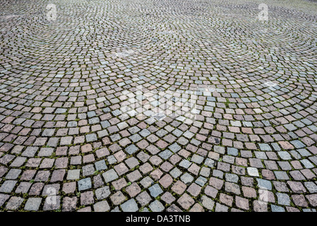 Cobblestone Street Brussels Belgium | BRUSSELS, Belgium — Weathered granite cobblestones pave a street in the Royal Quarter of central Brussels, their uneven, hand-laid surface a hallmark of the city's historic upper town. Cobbled paving of this kind dates largely to the 19th and early 20th centuries, when Brussels' major squares and boulevards were surfaced with quarried stone setts rather than modern asphalt. Stock Photo