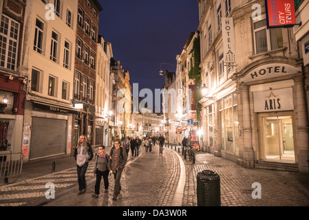 BRUSSELS, Belgium - Tourists walking along a cobblestone street in the Lower Town of Brussels, Belgium, at night. Stock Photo