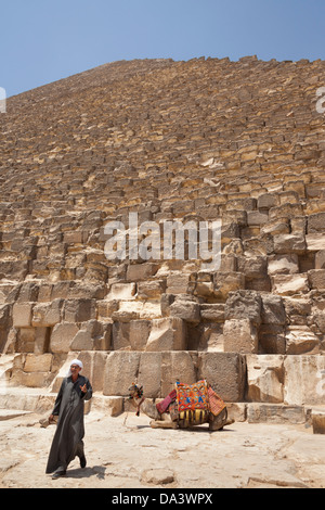 Man and camel beside Great Pyramid of Giza, also known as Pyramid of Khufu and Pyramid of Cheops, Giza, Cairo, Egypt Stock Photo