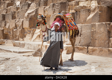 Man and camel beside Great Pyramid of Giza, also known as Pyramid of Khufu and Pyramid of Cheops, Giza, Cairo, Egypt Stock Photo