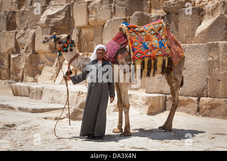 Man and camel beside Great Pyramid of Giza, also known as Pyramid of Khufu and Pyramid of Cheops, Giza, Cairo, Egypt Stock Photo