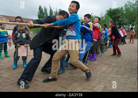 Primary school students take part in a tug-of-war competition in Haiyuan, Ningxia Hui Autonomous Region in China. 21-May-2013 Stock Photo