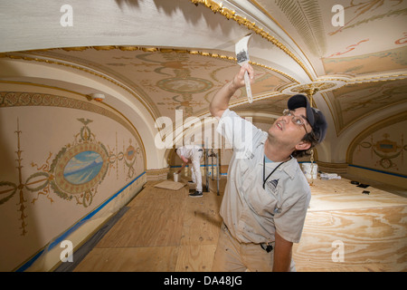 A room in the US Capitol building constructed in 1901 and decorated with murals designed by Elmer Garnsey is being restored by decorative painters July 2, 2013 in Washington, DC. The historic murals and lunettes in the room were conserved and an exact replica of the original border of which only a fragment remained were restored. Stock Photo