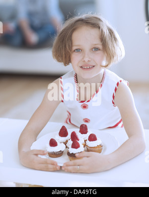 Young girl with plate of cupcakes Stock Photo