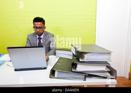 Portrait of Indian Businessman working on his laptop computer at his desk Stock Photo