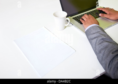 Close up of Indian mans hands typing on laptop Stock Photo