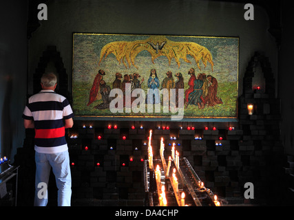 A man in front of the mosaic in the Chapel of the Holy Spirit, by Jewish artist Anna Wyner showing the event of Pentecost. Stock Photo
