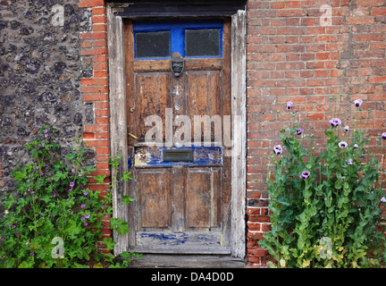 Old wooden doorway on a village high street in Norfolk. Stock Photo