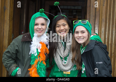 3 female spectators of the St. Patrick's Parade pose for a photograph, Dublin, Ireland, 17th of March 2013. Stock Photo