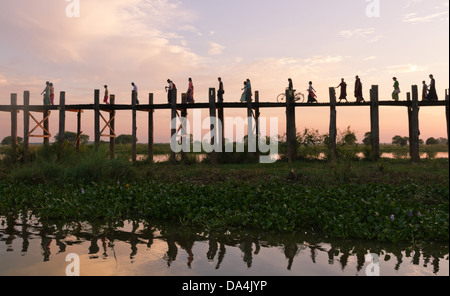 pedastrians cross wooden U-Bein bridge on October 28, 2011 in Amarapura, Burma. Stock Photo