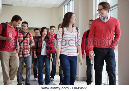 Group of students walking through college campus hallway