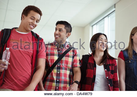 Group of students walking through college campus hallway