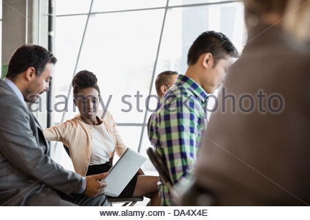Man and woman looking at laptop in business meeting Man and woman looking at laptop in business meeting