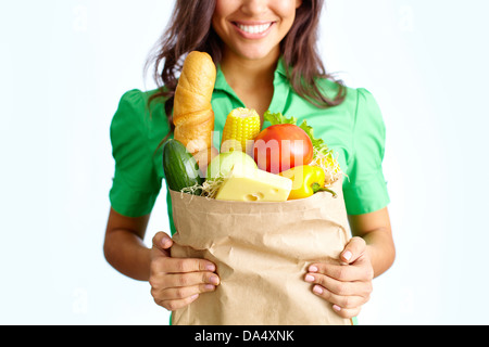 Image of big paper sack full of different fruits and vegetables in female hands Stock Photo