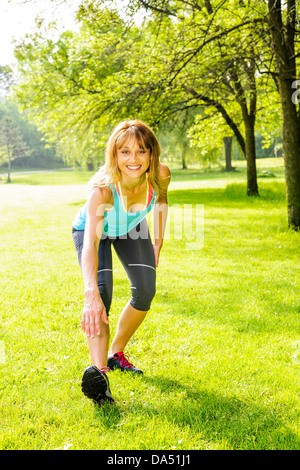 Fit blonde stretching in the park Stock Photo - Alamy