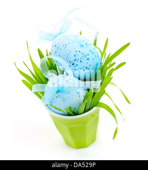 Blue Easter eggs arranged in cup with fresh green grass isolated on white Stock Photo